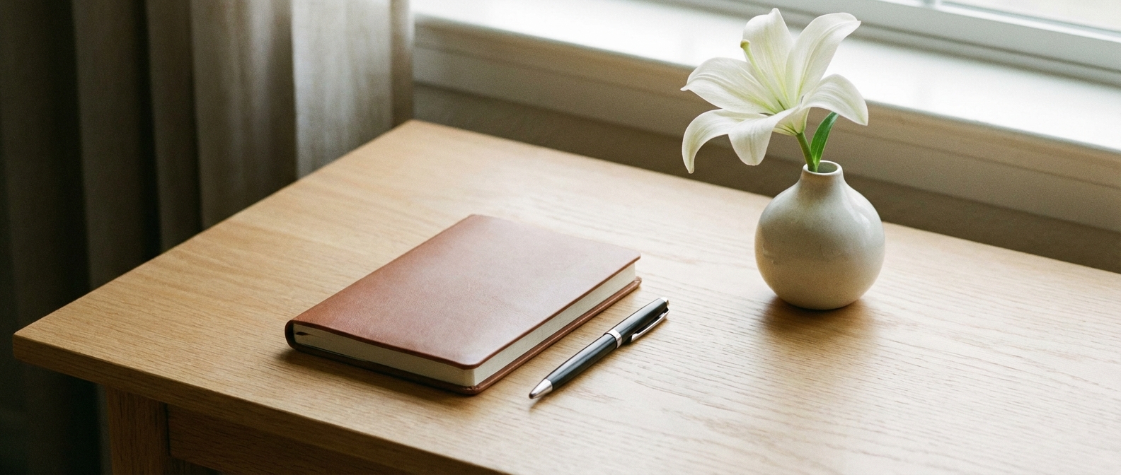Minimalist writing desk with notebook and white lily